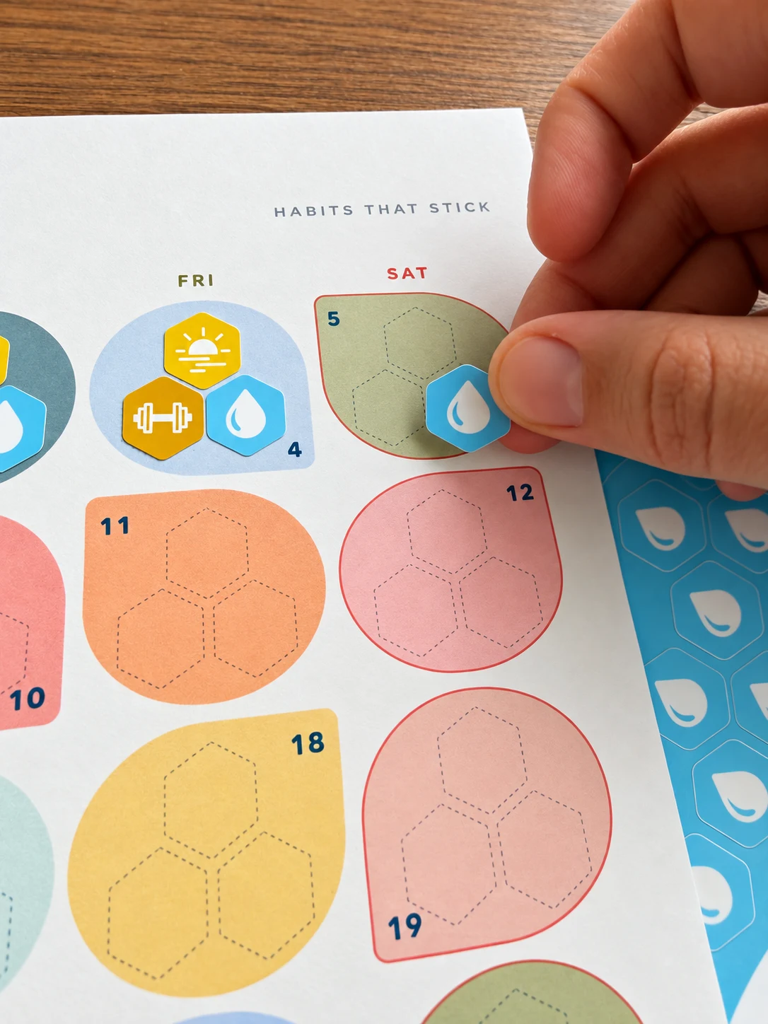 Hand placing a sticker on a calendar